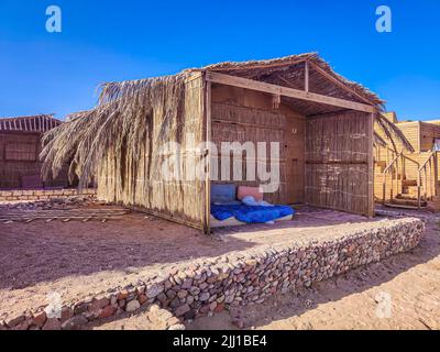 Cottage in a Bedouin Camp on the Sea in Ras Shitan in Oasis in Sinai, Taba desert with the Background of the Sea and Mountains. Stock Photo