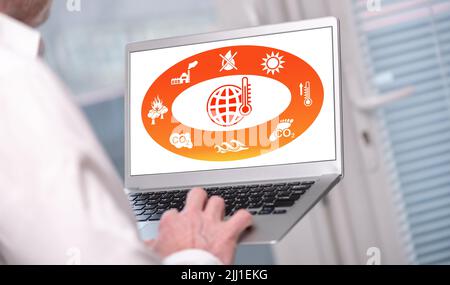Global warming concept shown on a laptop used by a man Stock Photo