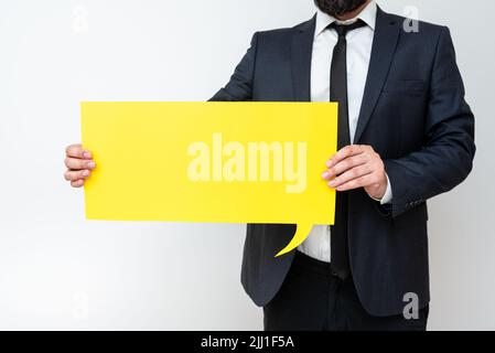 Businessman Holding Speech Bubble With Important Messages. Man In Suit Presenting Crutial Informations On Dialogue Balloon. Gentleman Showing Recent Stock Photo