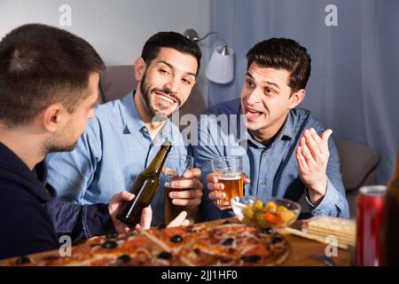 Friendly meeting in men company over beer with pizza Stock Photo
