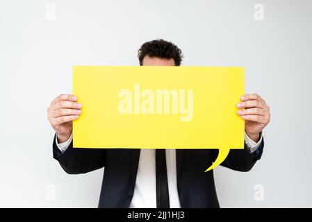 Businessman Holding Speech Bubble With Important Messages. Man In Suit Presenting Crutial Informations On Dialogue Balloon. Gentleman Showing Recent Stock Photo