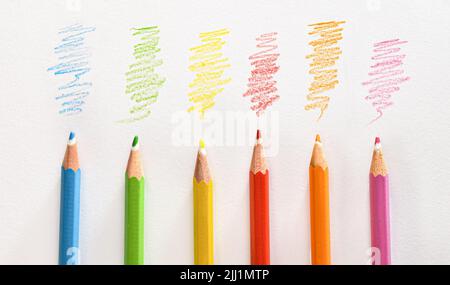 Detail of various colored pencils on white striped paper. Top view. Horizontal composition. Stock Photo