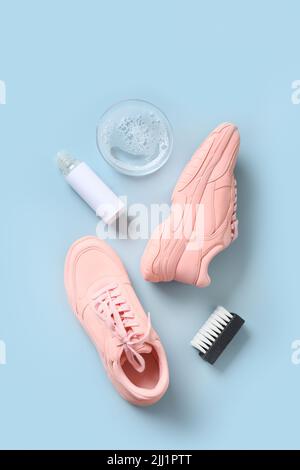 Concept washing sport sneakers with brush and special tool for cleaning them on blue background. Stock Photo