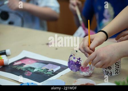 Kid painting something on a paper at school Stock Photo