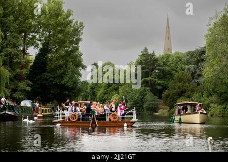Stratford Upon Avon, UK. 22nd July, 2022. A Baton Bearer carries the Commonwealth Games Queen's Baton onboard a ferry as it crosses the river Avon in Stratford Upon Avon Warwickshire Credit: Chris Radburn/Alamy Live News Stock Photo