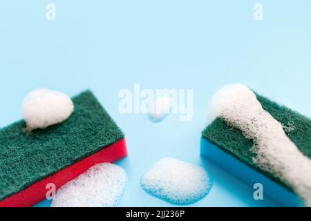 Multicolored sponges for cleaning on a blue background. Space for text Stock Photo