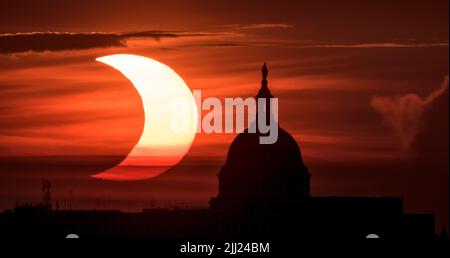 A partial solar eclipse is seen as the sun rises to the left of the United States Capitol building, Thursday, June 10, 2021, as seen from Arlington, Virginia. The annular or “ring of fire” solar eclipse is only visible to some people in Greenland, Northern Russia, and Canada. Photo Credit: (NASA/Bill Ingalls) Stock Photo