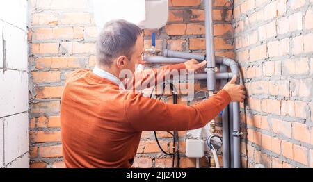 a plumber engineer repairing pipes at work Stock Photo