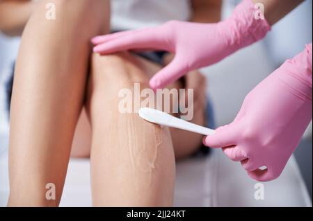 Close up of cosmetologist in sterile gloves applying ultrasound gel