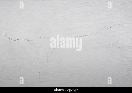The background is in the form of a section of white wall in a village house. Plastered wall and whitewashed with chalk. Old cracked plaster on the wal Stock Photo