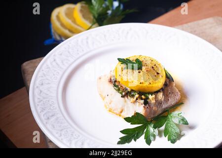 Healthy Food concept Homemade Lemon garlic butter Baked Cod fish on black background with copy space Stock Photo