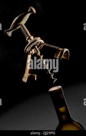 Bottle of wine with old-fashioned bottle opener Stock Photo