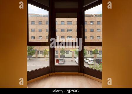 Window of a house in the corner of a room with black aluminum windows and mustard-colored walls and views Stock Photo