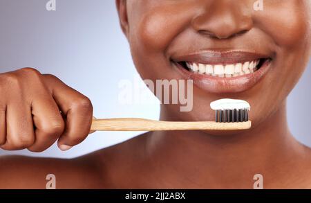 Brush them religiously. Studio shot of a beautiful young woman brushing her teeth. Stock Photo