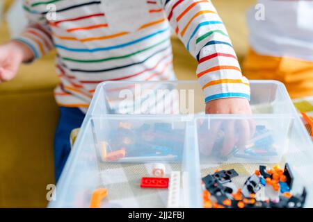 Kid collects robot from plastics details and programmed on tablet, robotics. Stock Photo