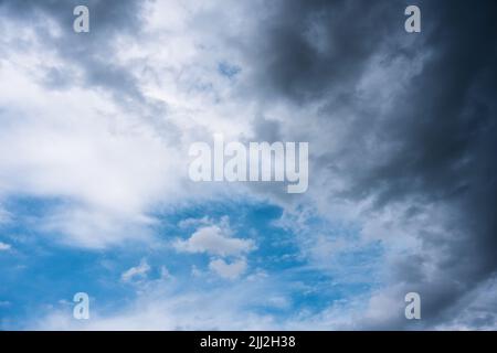 White cloud and storm cloud on blue sky in daylight before rain storm Stock Photo