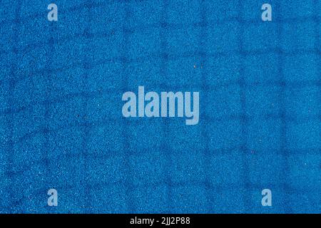 Colorful sports court background. Top view light blue field rubber ground with shadow from football goal net in sunny day outdoors Stock Photo