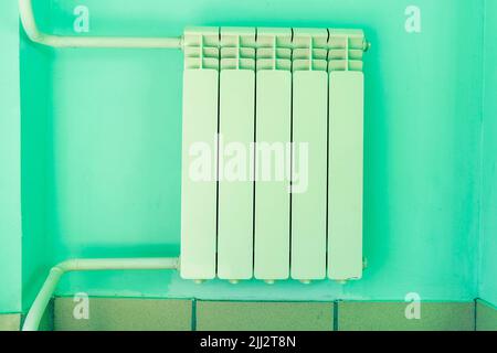 sectional radiator of the heater on the wall in room, heating pipes Stock Photo