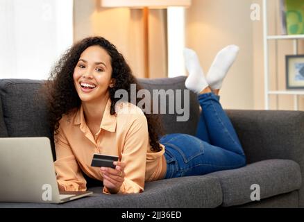 Secure your order. a woman holding a credit card while using her laptop. Stock Photo