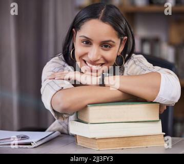 Miss independent...Almost. a young student doing her homework at the kitchen table. Stock Photo