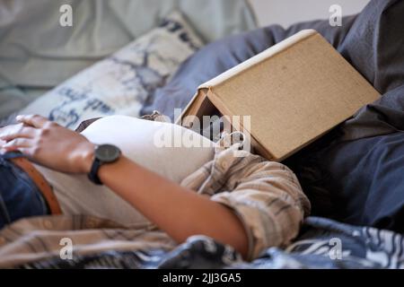 Just a quick nap. an unrecognizable student passed out while studying in her bedroom. Stock Photo