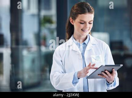 Getting some of her admin done between rotations. a young female doctor using a digital tablet in a hospital. Stock Photo