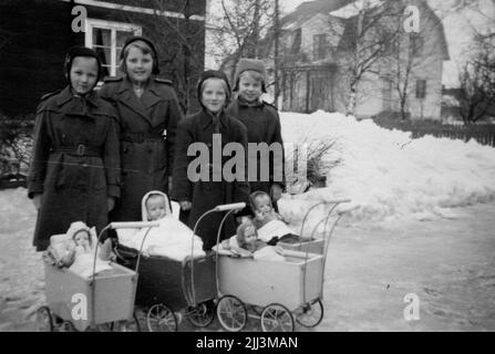 Four girls with dolls and doll carts. "Now it's March 1950, but the kids have not grown. Vitamin deficiency?" Gittan Gustavsson with their girlfriends, from left: Ingegerd, Ingrid, Ingrid, Gittan. (The pictures were taken by William Geidne, Gittan's dad). The toys in the picture (doll wagon, doll, doll clothes, sunglasses) were handed over to the museum, see item Ölm 38701: 1-12. The donor got the doll cart and the doll when she was 5 years old and played with them for 7 years. Her mother, Nanny Geidne (1910-1997) Örebro, sewed, crocheted and knitted doll clothes. Stock Photo