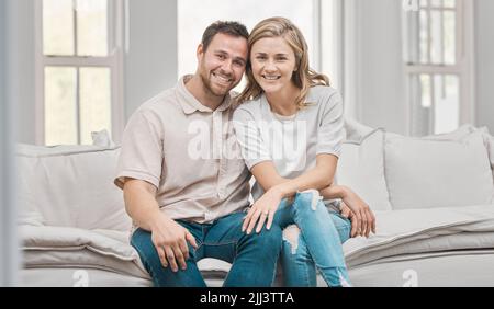 You stole my heart but Ill let you keep it. a young couple sitting on the sofa at home. Stock Photo