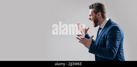 Distressful experience. Man face portrait, banner with copy space. Business man in suit, isolated studio background. Angry boss scream making wide Stock Photo