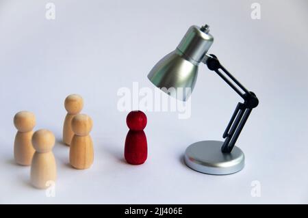 Table lamp focus on red wooden doll on white background. Copy space and business focus concept Stock Photo