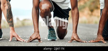 Theres nothing but you and the road. a group of people getting ready to run. Stock Photo