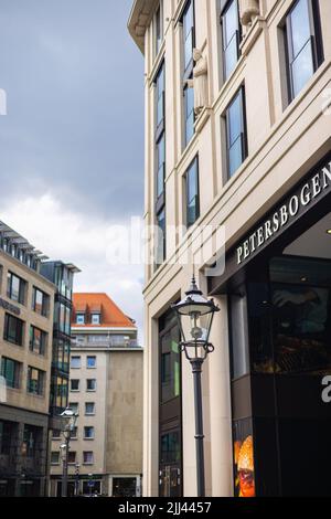 Leipzig, Germany - June 25, 2022: The Petersbogen at the finally completed Burgplatz. A historic street lamp in the foreground. Street view in the inn Stock Photo