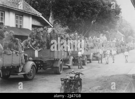 Pacific War, 1941-1945. After their capitulation to the invading Imperial Japanese 16th Army, Royal Netherlands East Indies Army (KNIL) troops are loaded onto trucks and await transport to prisoner-of-war camps, Dutch East Indies, circa March 1942. Stock Photo