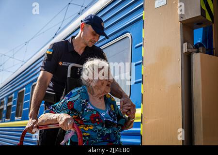 July 15, 2022, Pokorvsk, DonetsÃ-ka OblastÃ, Ukraine: A police officer can be seen helping an elderly in a wheelchair to board the evacuation train in Pokorvsk, Donetsk. Amid the intensified fighting in the Eastern part of Ukraine, millions of Ukrainian families now have been evacuating from the closer and closer war, as many of them will be relocated to the western part of the country.According to the United Nations, at least 12 million people have fled their homes since Russia's invasion of Ukraine, while seven million people are displaced inside the country. (Credit Image: © Alex Chan Tsz Stock Photo