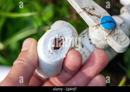 closeup shot of a male hand holding damaged pvc fitting Stock Photo
