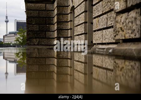 Berlin, Germany. 23rd July, 2022. The Berlin TV tower is reflected in a wet stone slab next to the Reichstag building in the morning. Credit: Christoph Soeder/dpa/Alamy Live News Stock Photo