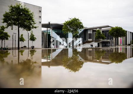 Berlin, Germany. 23rd July, 2022. The Marie-Elisabeth-Lüders-Haus (r) of the German Bundestag is reflected in a wet stone slab in the morning. Credit: Christoph Soeder/dpa/Alamy Live News Stock Photo