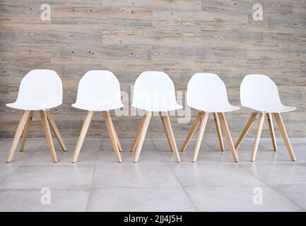 Everyone gets a chair. chairs lined up in an empty waiting area. Stock Photo