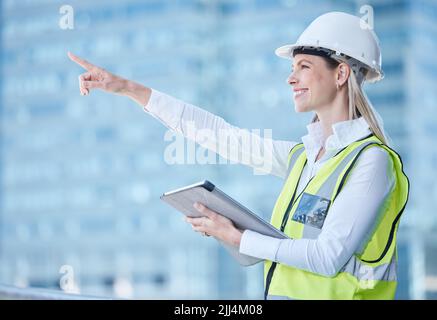 Watching my dreams unfold before me. a young female builder using her digital tablet for city planning. Stock Photo