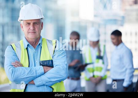Its a tough job. a senior foreman with his building team. Stock Photo