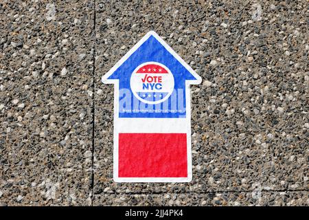 A NYC Board of Elections Vote NYC arrow sticker on the ground directs people to a polling site. Stock Photo