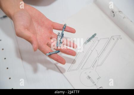 Screws in hand of man on the drawings background Stock Photo
