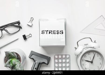 Blank of Notepad with the Word Stress, Pen, Clock and Antidepressants on white Background. Stop Depression. Education, Exam, Work Stress or Tension Stock Photo