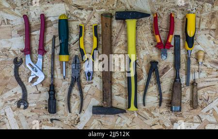 Old rusty tools versus modern tools on the OSB sheet. Concept: equipment upgrade. Tools: Hammer and pliers, chisel and screwdriver, awl amd wrench. Stock Photo