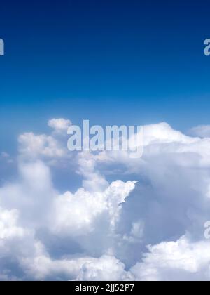 High up fluffy clouds. Beautiful sky view from airplane window. Air travel background with copy space. Looking out aircraft bull's eye. Beautiful sky Stock Photo
