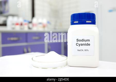 Selective focus of a bottle of Sodium Cyanide pure chemical compound used for cyanide fishing. White laboratory background. Stock Photo