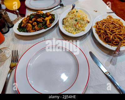 Chinese Restaurant Table setting with noodles, nasi and chicken in black bean sauce as served dishes Stock Photo