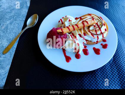 Baked Lemon Pie with blackcurrant cassis flavor ice cream next to it on a restaurant tablet setting. Perfect for cafetaria's and restaurants. Stock Photo