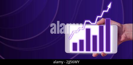 Businessman Holding A Tablet With Hand And Showing Crucial Data On Graphs In Futuristic Frame. A Palm Holding A Cellphone Displaying Progress Diagram Stock Photo
