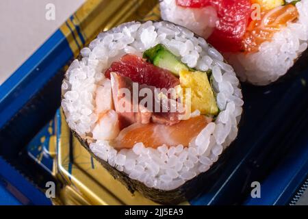 Takeout Kaisen Maki Zushi in plastic food tray. Norimaki in image rolled out by Shiso leaf, salmon, fried egg(Tamago Yaki), tuna (Maguro) and cucumber Stock Photo